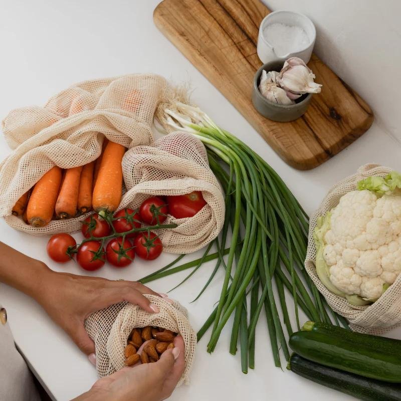 Fresh produce on the kitchen bench — carrots, tomatoes, cauliflower, garlic, spring onions and zucchini